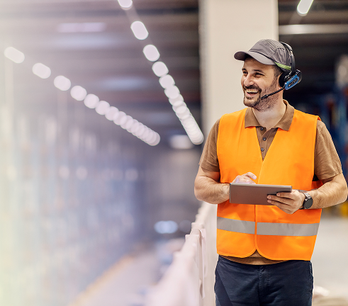 A distribution operator checking stock against a handheld tablet