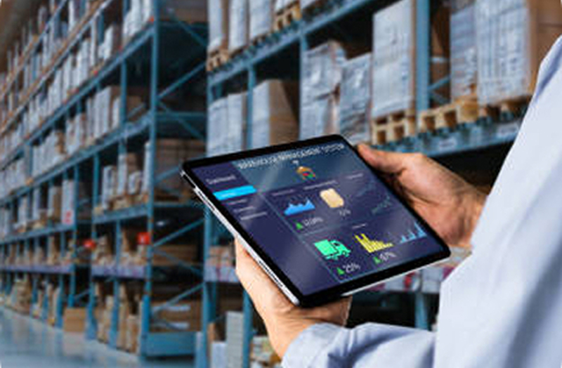 A distribution dashboard open on a tablet in front of warehouse racking